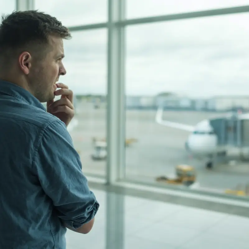 Anxious man in airport with flying phobia